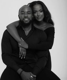 a black and white photo of a man hugging a woman's back with her arm around him