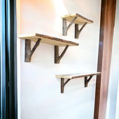 three wooden shelves are mounted on the wall