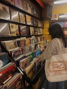 a woman is walking down the stairs in a record store