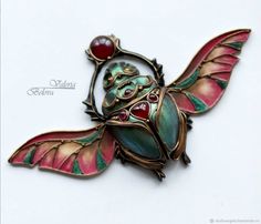 a close up of a brooch with a butterfly on it's back end