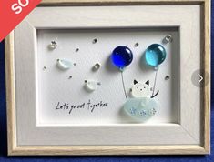 a white frame with three glass balloons in it and the words let's get together