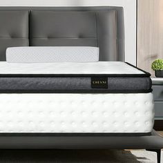 a bed with a black headboard and white mattress on it's side in a room