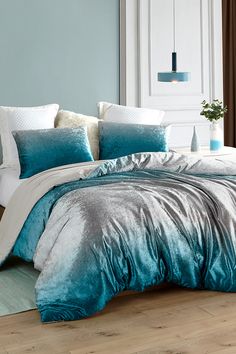 a bed with blue and white comforters in a bedroom