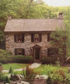 a stone house surrounded by trees and rocks