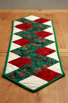 a green and red table runner on top of a wooden floor