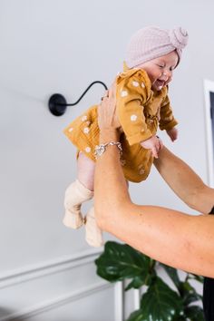 a woman holding a baby up in the air