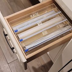 an open drawer with plastic wrap on the bottom and four clear tubes in each drawer