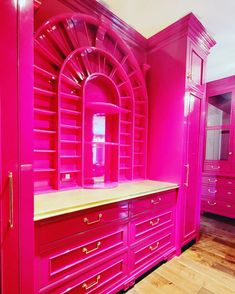 a room with pink furniture in it and wooden floors on one side, an arched window to the other