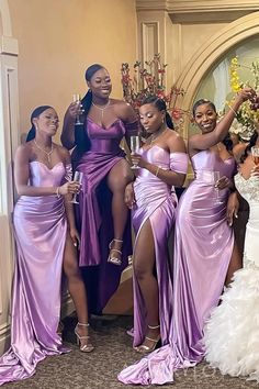 the bridesmaids are posing for a photo in their purple gowns and champagne flutes