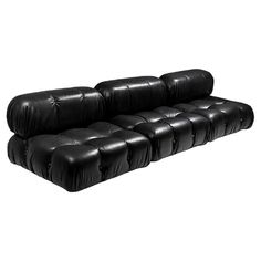 a black leather couch sitting on top of a white floor