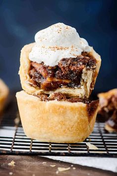 a pastry topped with whipped cream on top of a cooling rack next to other pastries