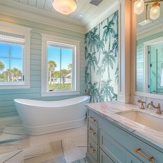 a bathroom with blue and white wallpaper has a large bathtub in the center