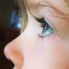 a young child's blue eye with long lashes