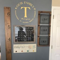 a room with a growth chart, ruler and wall decals on the walls that read our family