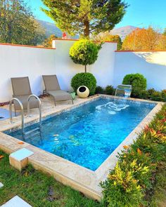 an empty swimming pool in the middle of a yard with lawn chairs and trees around it