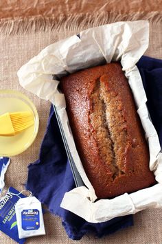 a loaf of banana bread sitting on top of a blue cloth next to some butter