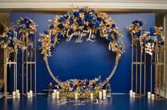 a blue and gold wedding set up with flowers, candles and an arch that says george's club