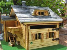 a small wooden house sitting on top of a lush green field