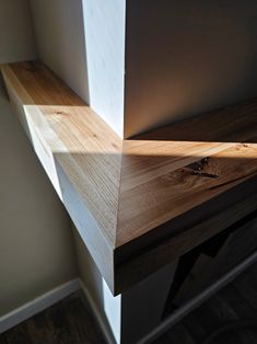 a close up of a wooden shelf with sunlight coming through the gap in the wall