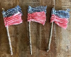 three red, white and blue bows are on sticks