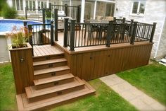 a deck with steps and railings next to a swimming pool