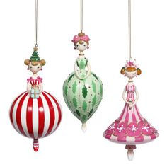 three christmas ornaments hanging from strings on a white background, each with different designs and colors