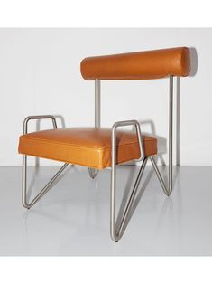 an orange leather chair with metal legs and seat pad on the back, in front of a white wall