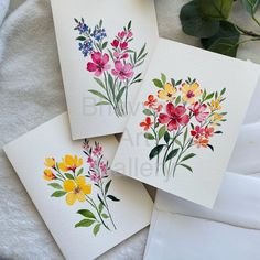 three cards with watercolor flowers on them