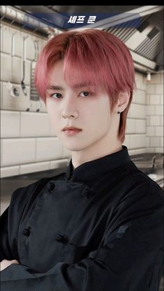 a man with pink hair standing in a kitchen