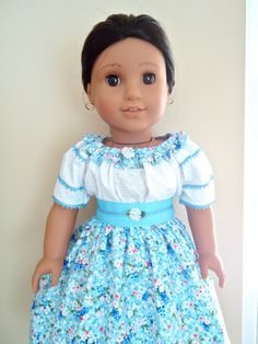 the doll is wearing a blue dress with flowers on it