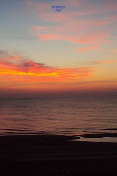 the sun is setting over the ocean and there are clouds in the sky