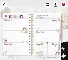 an open planner book with rainbows and hearts on the pages, next to flowers