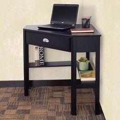 a laptop computer sitting on top of a wooden desk next to a book shelf with books