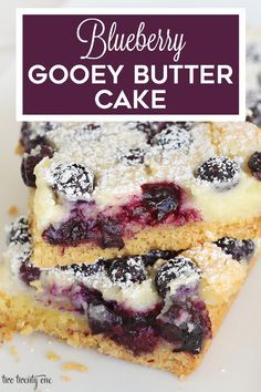 two blueberry gooey butter cake bars stacked on top of each other