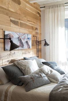 a bedroom with wood paneling and pillows on the bed