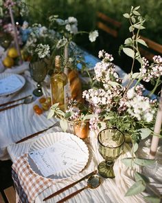 the table is set with flowers and plates