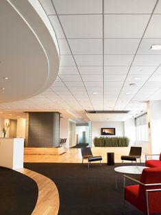 an empty office with red chairs and black carpeted flooring in front of a white wall