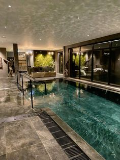 a large indoor swimming pool in the middle of a room with glass doors on both sides