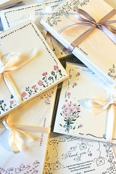 many wedding cards with ribbons tied around them and flowers on them, all in different designs