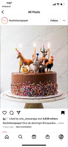 a birthday cake with candles on it and animals in the frosting, surrounded by sprinkles