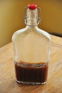 a glass bottle filled with liquid sitting on top of a wooden table