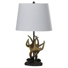 an antler lamp with a white shade on the base and a black base underneath it