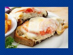 two pieces of bread with cheese and tomato on it, next to some french fries