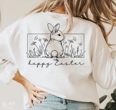 a woman wearing a happy easter sweatshirt with an image of a bunny on the front