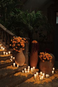 several vases filled with flowers and lit candles on the steps in front of a house