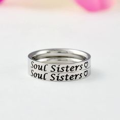 "This listing is for 2 stainless steel band rings, engraved with \"Soul Sisters\" + a heart symbol on the outside. It makes a lovely cute gift for best friends, forever sisters. Materials & Features: This ring is made of high quality hand polished solid stainless steel, which is hypoallergenic (good for metal-sensitive skin). Stainless steel will not tarnish, its luster and durability will make it last for many years. The black text on the ring will not fade out over time. Sizes: This ring is 3m Christmas Bridesmaids, Sisters Best Friends, Beeswax Taper Candles, Friend Bff, Sorority Sisters, Heart Symbol, Stacking Bands, Fade Out, Gemstone Stud Earrings