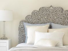 a bed with white pillows and blue headboard