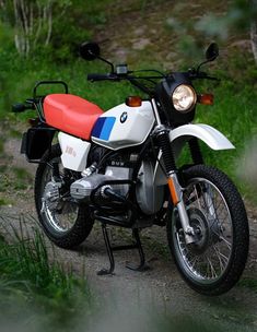 a white and red motorcycle parked on the side of a road next to some grass