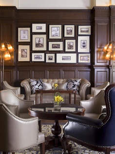 a living room filled with furniture and framed pictures