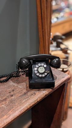 an old fashioned telephone sitting on top of a wooden table